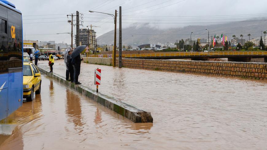 People  stand near a flooded street after a flash flooding in Shiraz, Iran, March 26, 2019. Tasnim News Agency/via REUTERS ATTENTION EDITORS - THIS PICTURE WAS PROVIDED BY A THIRD PARTY - RC1E3933B310