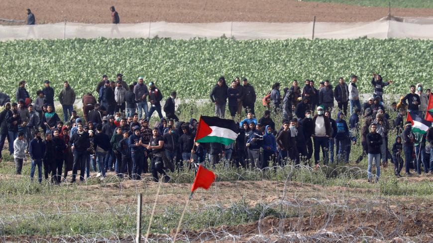 Palestinians gather near the border fence between Israel and the Gaza Strip during a protest, as it is seen from its Israeli side March 30, 2019 REUTERS/ Amir Cohen - RC1F3065EFA0