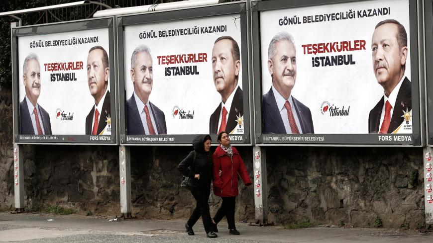 People walk past by AK Party billboards with pictures of Turkish President Tayyip Erdogan and mayoral candidate Binali Yildirim in Istanbul, Turkey, April 1, 2019. The billboards read: " Thank you Istanbul ".  REUTERS/Murad Sezer - RC1FFDD2DBA0