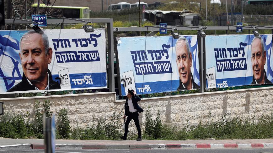 An ultra-Orthodox Jewish man walks past a Likud election campaign poster depicting Israeli Prime Minister Benjamin Netanyahu in Jerusalem April 7, 2019. REUTERS/Ammar Awad - RC1CC13589E0
