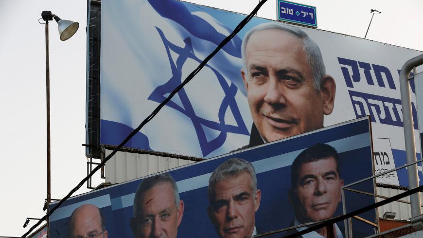 A Likud party election campaign billboard depicting Israeli Prime Minister Benjamin Netanyahu is seen above a billboard depicting Benny Gantz, leader of Blue and White party, together with his top party candidates Moshe Yaalon, Yair Lapid and Gaby Ashkenazi, in Petah Tikva, Israel April 7, 2019. REUTERS/Nir Elias - RC14AD4D6860