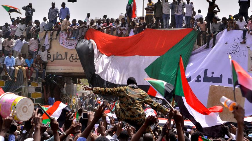 A military officer is carried by the crowd as demonstrators chant slogans and carry their national flags, after Sudan's Defense Minister Awad Mohamed Ahmed Ibn Auf said that President Omar al-Bashir had been detained "in a safe place" and that a military council would run the country for a two-year transitional period, outside Defence Ministry in Khartoum, Sudan April 11, 2019. REUTERS/Stringer     TPX IMAGES OF THE DAY - RC158D03E8D0