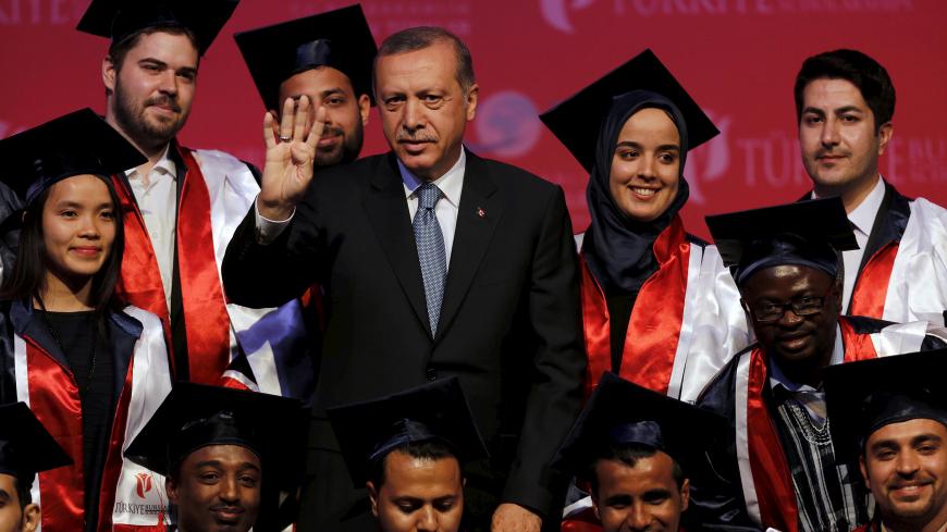 Turkey's President Tayyip Erdogan poses with students during a graduation ceremony in Ankara, Turkey, June 11, 2015. President Erdogan on Thursday urged the country's political parties to work quickly to form a new government, saying egos should be left aside and that history would judge anyone who left Turkey in limbo. In his first public appearance since Sunday's parliamentary election, Erdogan said no political development should be allowed to threaten Turkey's gains. He said he would do his part in find