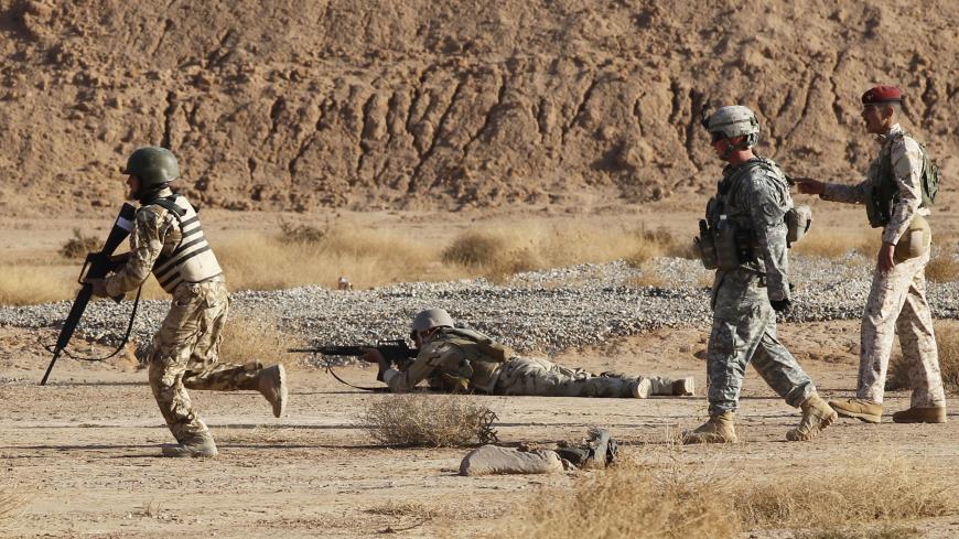 A U.S. soldier (2nd R) watches Iraqi soldiers firing at targets during a training course at a military base close to the Iranian border December 21, 2010. The U.S. army trained about 300 Iraqi soldiers on assault techniques and shooting at targets on Tuesday. Picture taken December 21, 2010. REUTERS/Mohammed Ameen (IRAQ - Tags: CONFLICT MILITARY) - GM1E6CM1RX001