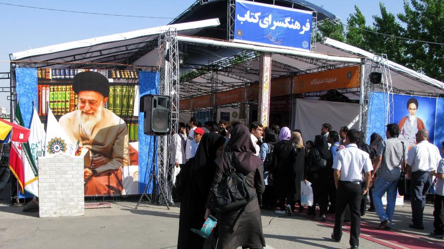 TEHRAN, IRAN - MAY 4, 2008: People visit book stands with pictures of Ayatollah Khomeini (R) and Ayatollah Ali Khamenei (L) displayed outside, at the 21st Tehran International Book Fair on the city's congregational prayer site on May 4, 2008 in Tehran, Iran. The annual event showcases 200,000 titles from 1700 domestic and 840 international publishers from 75 countries. The books will be presented under categories for General, Academic, Educational and Children's books. (Photo by Kaveh Kazemi/Getty Images)
