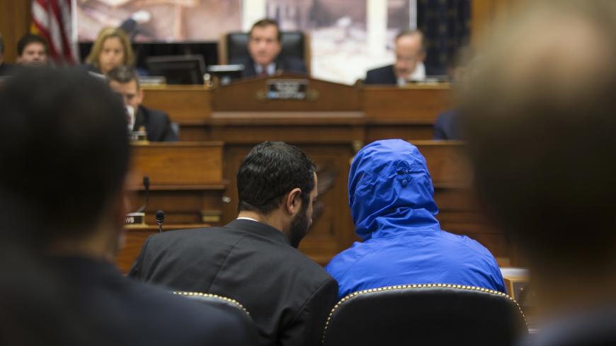 ATTENTION EDITORS - VISUAL COVERAGE OF SCENES OF INJURY OR DEATH
The man credited with smuggling 50,000 photos said to document Syrian government atrocities, a Syrian Army defector known by the protective alias Caesar (disguised in a hooded blue jacket), listens to his interpreter as he prepares to speak at a briefing to the House Foreign Affairs Committee on Capitol Hill in Washington July 31, 2014. REUTERS/Jonathan Ernst (UNITED STATES - Tags: POLITICS MILITARY CONFLICT) TEMPLATE OUT - GM1EA7V1SKN01