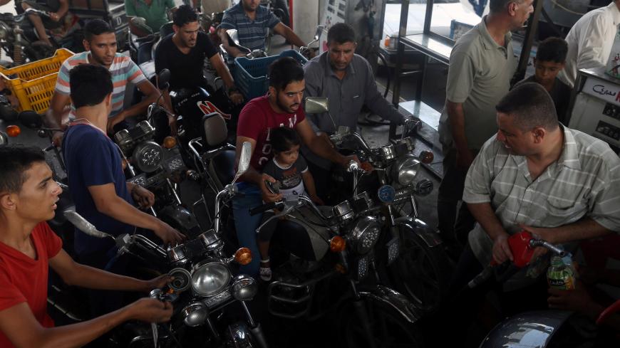 Palestinians wait to fill their motorcycle with fuel after Israel stopped the transfer of fuel and cooking gas into Gaza, at a petrol station in Khan Younis in the southern Gaza Strip July 17, 2018. REUTERS/Ibraheem Abu Mustafa - RC1C7416D220