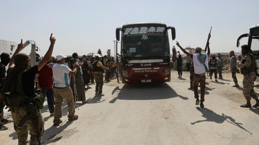 Islamist rebels from Hayat Tahrir al-Sham celebrate for their families and relatives who are released from government prisons, as they arrive to El Eis area in southern Aleppo, Syria July 19, 2018. REUTERS/Khalil Ashawi - RC1418535730