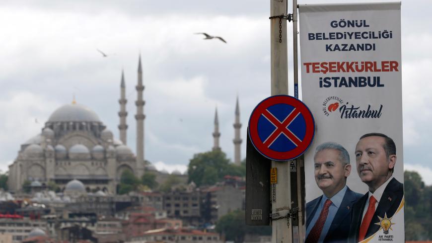 An election banner with the pictures of Turkish President Tayyip Erdogan and AK Party mayoral candidate Binali Yildirim is seen over the Galata bridge in Istanbul, Turkey, May 7, 2019. REUTERS/Murad Sezer - RC1157E63D00