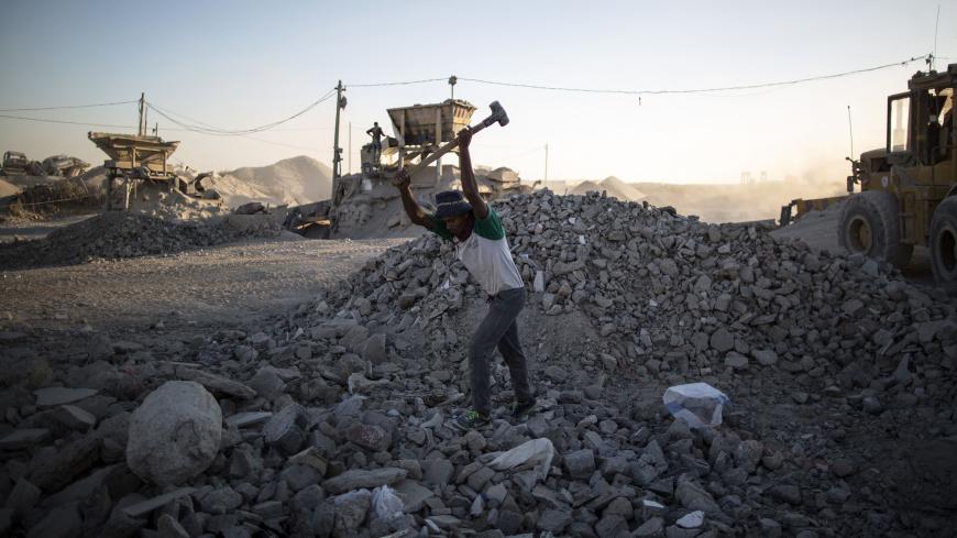 TOPSHOT - A Palestinian worker breaks stones at a factory where the rubble of houses, that were destroyed during wars, are recycled to be reused at construction sites on November 6, 2016 in Gaza City. / AFP / MAHMUD HAMS        (Photo credit should read MAHMUD HAMS/AFP/Getty Images)