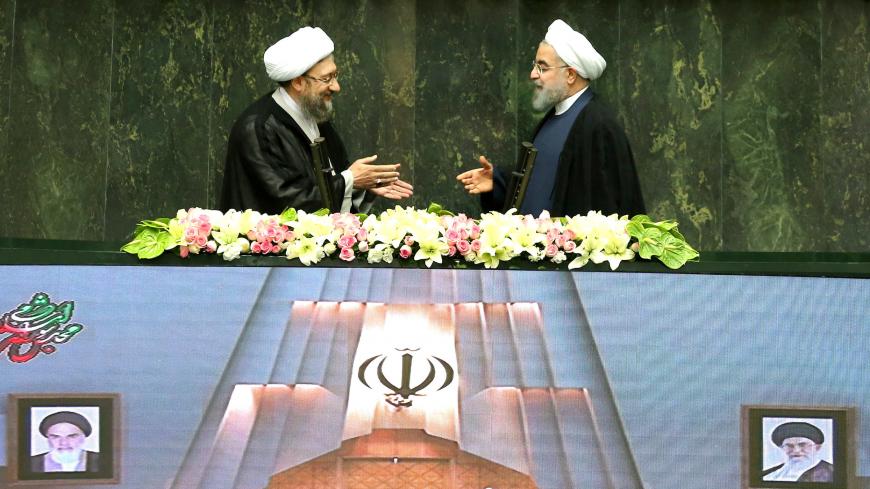 Iranian president Hassan Rouhani extends his hand to Iran's Judiciary Chief Sadegh Larijani during a swearing-in ceremony for Rouhani for a further term, at the parliament in Tehran, Iran, August 5, 2017. Nazanin Tabatabaee Yazdi/TIMA via REUTERS ATTENTION EDITORS - THIS IMAGE WAS PROVIDED BY A THIRD PARTY.     TPX IMAGES OF THE DAY - RC15208A0ED0