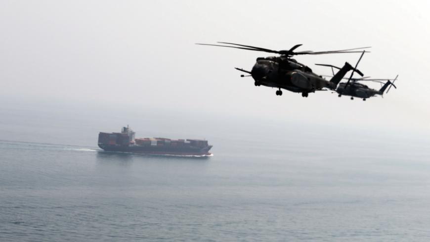 U.S. Navy MH-53E Sea Dragon helicopters are seen making their way to an exercise area as they take part in a U.S. and U.K. Mine Countermeasures Exercise (MCMEX) taking place at the Arabian Sea, as a cargo ship is seen sailing towards Straits of Harmoz, September 10, 2018. REUTERS/Hamad I Mohammed - RC1B39C2A3E0