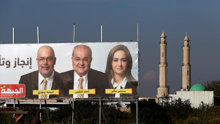 Mosque minarets are seen next to an election campaign banners depicting Ahmad Tibi, from of the Hadash-Ta'al party in the Israeli-Arab village of Taibe, northern Israel April 3, 2019. Picture taken April 3, 2019. REUTERS/Ammar Awad - RC1D1EEB7CC0