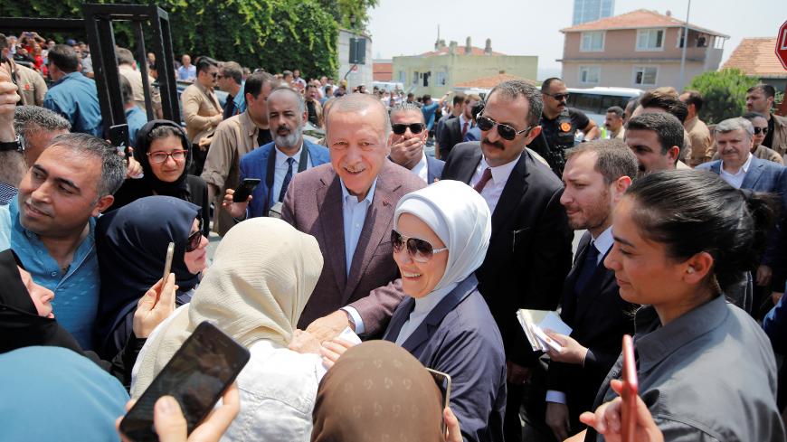 Turkish President Tayyip Erdogan and his wife Emine greet people after casting their ballots, outside a polling station in Istanbul, Turkey, June 23, 2019. REUTERS/Kemal Aslan - RC1FC934CEE0