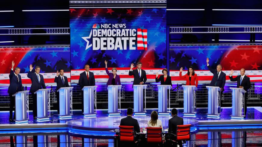 All candidates except U.S. Senator Cory Booker raise their hands while responding to a question that they would currently support the original Iran nuclear agreement during the first U.S. 2020 presidential election Democratic candidates debate in Miami, Florida, U.S., June 26, 2019. REUTERS/Mike Segar     TPX IMAGES OF THE DAY - HP1EF6R065EGH