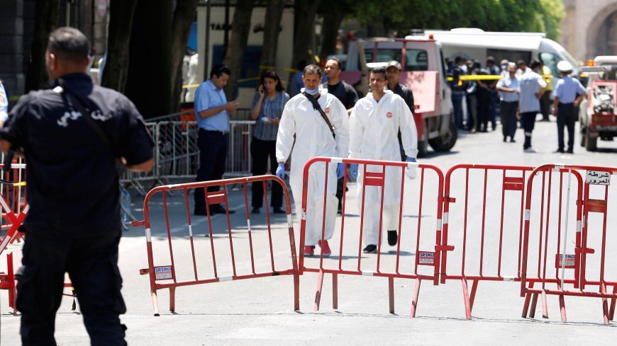 Forensic experts walk at the site of a suicide bombing attack in downtown Tunis, Tunisia June 27, 2019.  REUTERS/Zoubeir Souissi - RC19116BC750