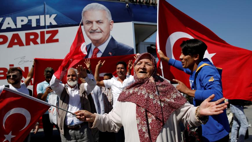 Supporters of ruling AK Party wave Turkish flags at an election kiosk of their Istanbul mayoral candidate Binali Yildirim in Istanbul, Turkey, June 3, 2019. REUTERS/Murad Sezer - RC1E72A54000