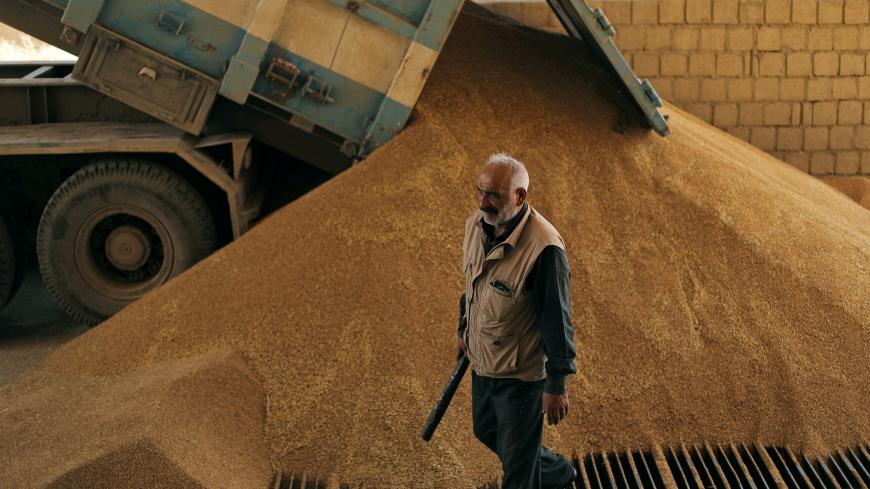 A driver unloads wheat grains from a truck at a mill in Qamishli, Syria June 3, 2019. Picture taken June 3, 2019. REUTERS/Rodi Said - RC11132FBEF0
