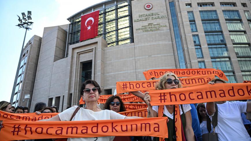 People hold scarf banners reading " Do not touch my teacher" during a demonstration outside of Istanbul's courthouse and before a trial of two academics on July 16, 2019. - Fusun Ustel was also detained on May 8, 2019 after being sentenced to 15 months in prison for having signed the peace petition in 2016 with 1,127 other Turkish academics. Tuna Altinel, an official of the French state, is being prosecuted in his country as hundreds of other academics for having signed in 2016 the "petition for peace" whic