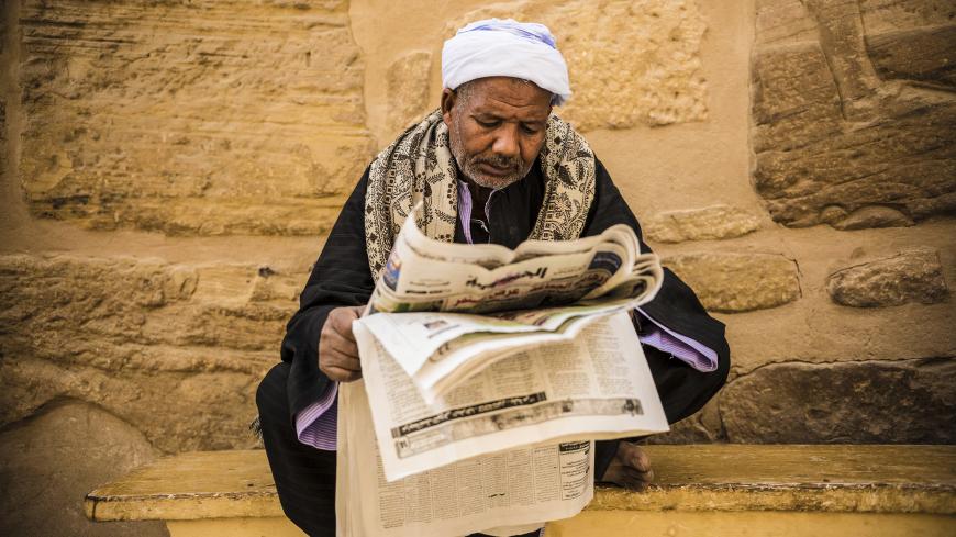 LUXOR, EGYPT - FEBRUARY 19: A tourist guide reads newspaper at Ramesses III. Mortuary Temple, also known as Medinet Habu Complex in west of Luxor, Egypt on February 19, 2015. The Temple is an important ancient Egypt's New Kingdom period structure, probably best known as the source of inscribed reliefs depicting the advent and defeat of the Sea Peoples during the reign of Ramesses III. (Photo by Ahmed Zakaria/Anadolu Agency/Getty Images)