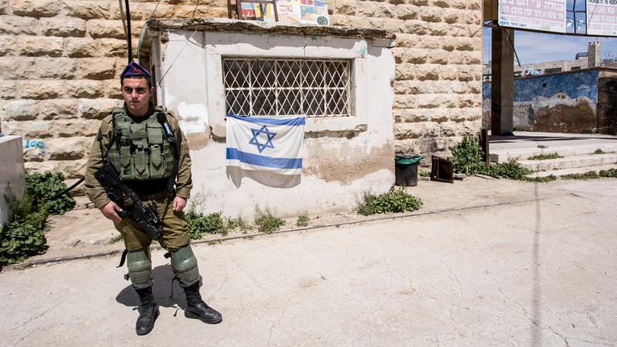 Young Israeli soldier watch and entrance to Jewish settlement on Shuhada Street in Hebron, West Bank on April 6, 2019. Shuhada street used to be the main street of old town of Hebron with Palestinian homes and small businesses, since 1994 Palestinians have restricted access to the street. Israeli army base in the area to protect Israeli settlers and watch access to Abraham mosque and synagogue. (Photo by Dominika Zarzycka/NurPhoto via Getty Images)