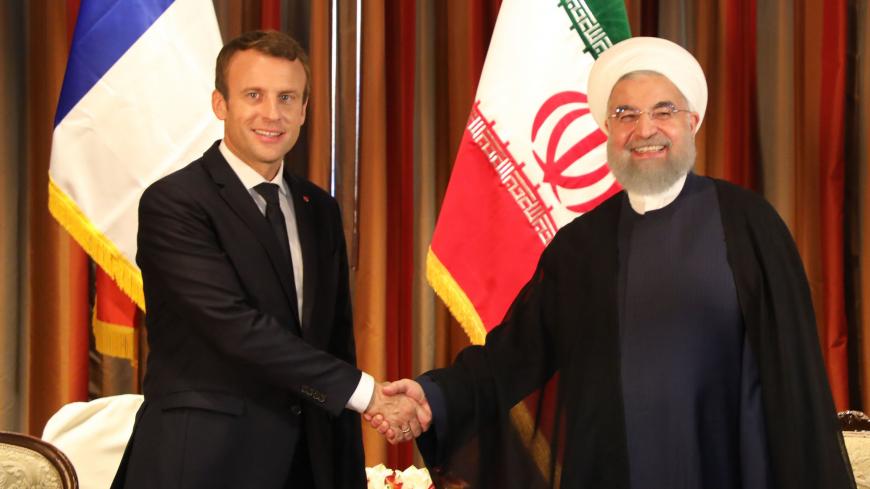 France's President Emmanuel Macron (L) shakes hands with his Iranian counterpart Hassan Rouhani as Iran's foreign minister, Mohammad Javad Zarif (3rd R) and other members of the Iranian delegation stand next to them during an official meeting at the Millennium Hotel near the United Nations on September 18, 2017, in New York. / AFP PHOTO / LUDOVIC MARIN        (Photo credit should read LUDOVIC MARIN/AFP/Getty Images)