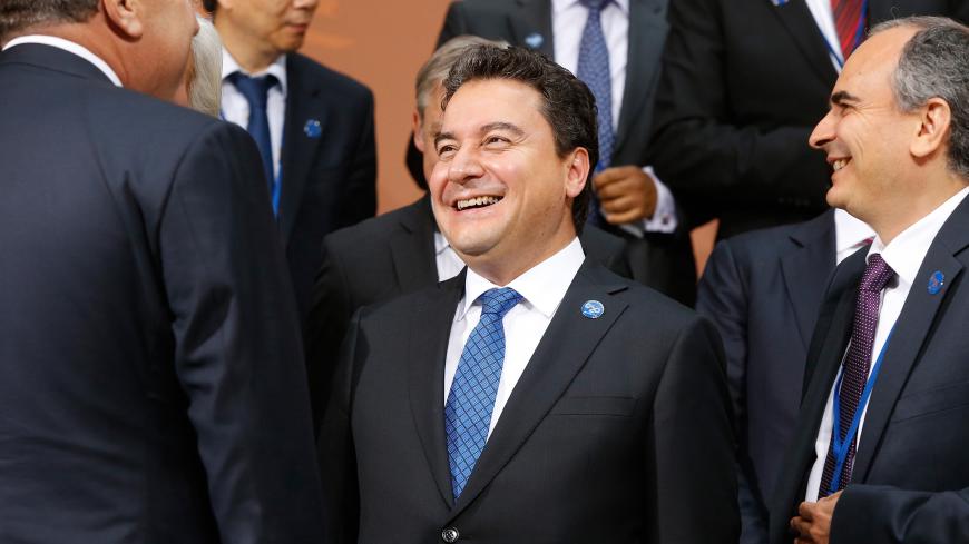 Turkey's Deputy Prime Minister Ali Babacan smiles as delegates gather for a family photo after a meeting of G-20 finance ministers and central bank governors during the IMF-World Bank annual meetings in Washington October 10, 2014. Also pictured is Turkey's Central Bank Governor Erdem Basci (R). REUTERS/Jonathan Ernst (UNITED STATES - Tags: POLITICS BUSINESS) - GM1EAAB08NN01
