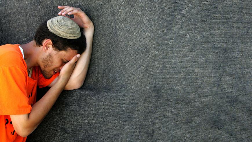 An Israeli opponent of Israel's disengagement plan from Gaza mourns as he prays on the roof of a synagogue in Kfar Darom.  An Israeli opponent of Israel's disengagement plan from Gaza mourns as he prays before evacuation by special evacuation policemen on the roof of a synagogue in the Jewish Gaza Strip settlement of Kfar Darom on August 18, 2005. In the most violent scenes since the start of forced evictions from Gaza, police armed only with shields poured from a cage hoisted on top of the synagogue and gr