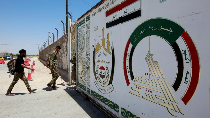 Members of Iraqi Popular Mobilization Forces (PMF) walk as they enter their headquarters in the holy city of Najaf, Iraq July 2, 2019. REUTERS/Alaa Al-Marjani - RC1350C4F160