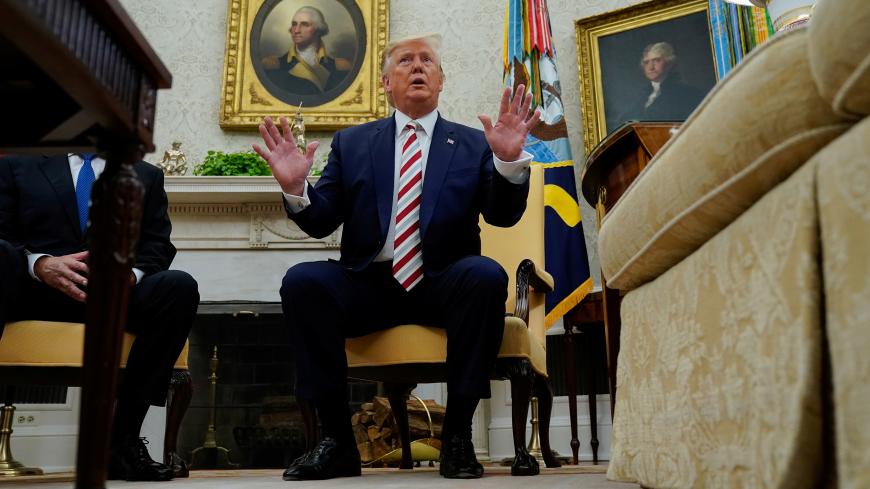 U.S. President Donald Trump answers questions from reporters while sitting in front of portraits of former U.S. presidents George Washington and Thomas Jefferson as he meets with Romania's President Klaus Iohannis in the Oval Office of the White House in Washington, U.S. August 20, 2019.   REUTERS/Kevin Lamarque - RC16D514D880