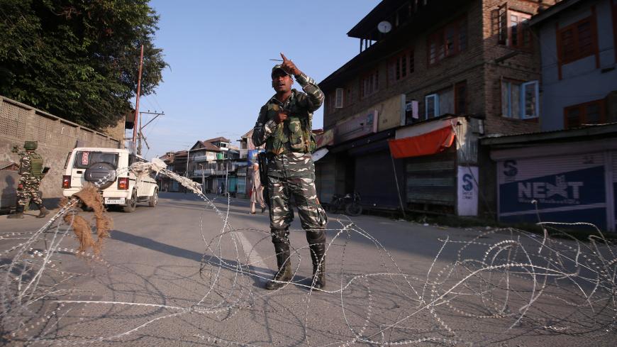 An Indian security personnel stands guard on a deserted road during restrictions after scrapping of the special constitutional status for Kashmir by the Indian government, in Srinagar, August 23, 2019. REUTERS/Danish Ismail - RC1EC752B830