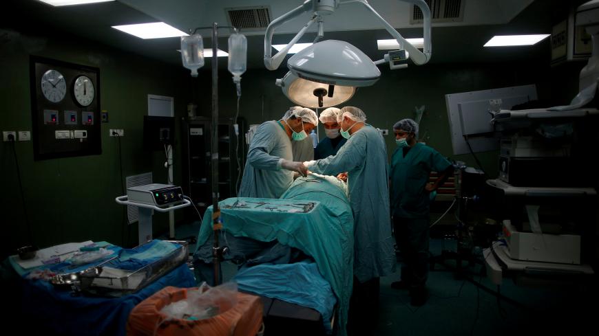 Doctors and medics perform a surgery for Palestinian woman Sadeya al-Shafi, 60, in the operating room at Shifa hospital, Gaza's largest public medical facility, in Gaza City, March 29, 2017. REUTERS/Mohammed Salem             SEARCH "GAZA HEALTH" FOR THIS STORY. SEARCH "WIDER IMAGE" FOR ALL STORIES. - RC1EFFBDF050