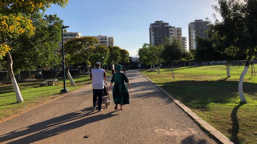 Visitors walk on down a path at a park in the northern Israeli town of Afula, July 13, 2019. Picture taken July 13, 2019. REUTERS/Rami Ayyub - RC127FCC8540