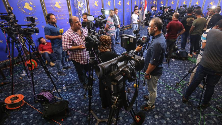This picture taken on October 2, 2018 shows Iraqi journalists performing interviews at the federal parliament headquarters in Iraq as the legislative assembly meets to elect a new president for the country. (Photo by Ahmad AL-RUBAYE / AFP)        (Photo credit should read AHMAD AL-RUBAYE/AFP/Getty Images)