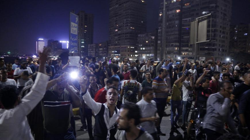 Egyptian protesters shout slogans as they take part in a protest calling for the removal of President Abdel Fattah al-Sisi in Cairo's downtown on September 20, 2019. - Protestors also gathered in other Egyptian cities calling for the removal of President Abdel Fattah al-Sisi but police quickly dispersed them. In Cairo dozens of people joined night-time demonstrations around Tahrir Square -- the epicenter of the 2011 revolution that toppled the country's long-time autocratic leader. (Photo by STR / AFP)     
