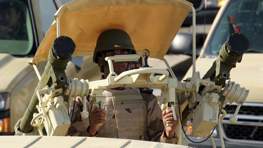 A member of the Iraqi army sits on a vehicle mounted with a man-portable air-defence system (MANPAD) during a yearly military show on February 1, 2015 in the capital Baghdad. Violence in Iraq killed 1,375 people in January, month eight of the battle against jihadists who swept through large areas of the country last summer, the United Nations said. AFP PHOTO / SABAH ARAR        (Photo credit should read SABAH ARAR/AFP/Getty Images)