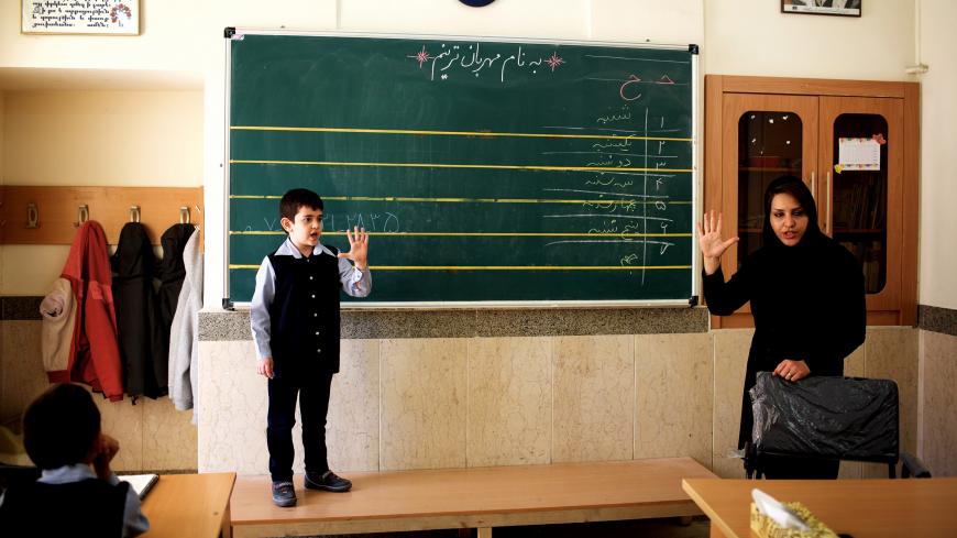 Iranian Muslim teacher Noushin Beigi (R) and an Armenian schoolboy gesture during a  mathematics class at the Armen school, in the Julfa neighbourhood in the historic city of Isfahan, some 400 kms south of the capital Tehran, on April 20, 2015. Julfa neighborhood in Isfahan is where the biggest Armenian community in Iran resides and was established as an Armenian quarter by Persian Safavid King Shah Abbas I in 1606. Some 180.000 Armenians were living in Iran before the Islamic revolution in 1979, compared t