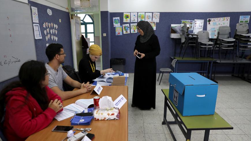An Israeli-Arab woman prepares to casts her ballot as Israelis vote in a parliamentary election, at a polling station in Umm al-Fahm, Israel April 9, 2019. REUTERS/Ammar Awad - RC1E94535020