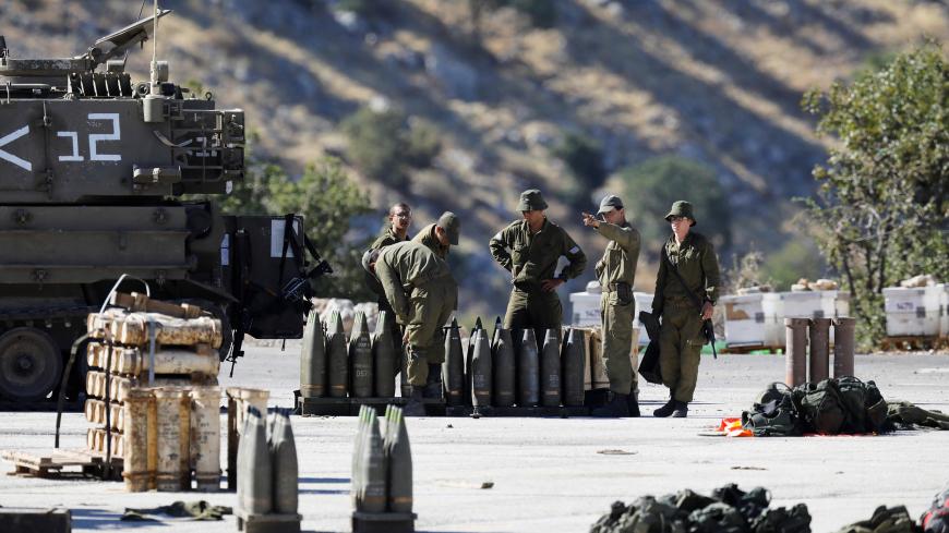 Israeli soldiers stand next to shells and a mobile artillery unit near the Israeli side of the border with Syria in the Israeli-occupied Golan Heights August 26, 2019. REUTERS/Amir Cohen - RC1C67173F10