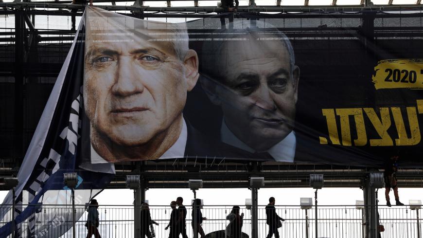 Labourers hang a banner depicting Benny Gantz, leader of Blue and White party, and Israel Prime minister Benjamin Netanyahu, as part of the party's campaign ahead of the upcoming election, in Tel Aviv, Israel February 17, 2020. REUTERS/Ammar Awad - RC2D2F9IS3LH