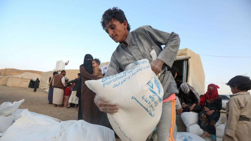 A man carries a sack of wheat flour he received at a camp for people recently displaced by fighting in Yemen's northern province of al-Jawf between government forces and Houthis, in Marib, Yemen March 8, 2020. Picture taken March 8, 2020. REUTERS/Ali Owidha - RC29GF9R1PMN