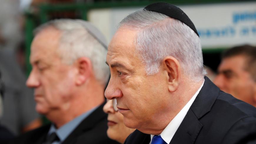 Israeli Prime Minister Benjamin Netanyahu looks on as he sits next to Benny Gantz, leader of Blue and White party, during a memorial ceremony for late Israeli President Shimon Peres, at Mount Herzl in Jerusalem September 19, 2019. REUTERS/Ronen Zvulun - RC140183F6E0