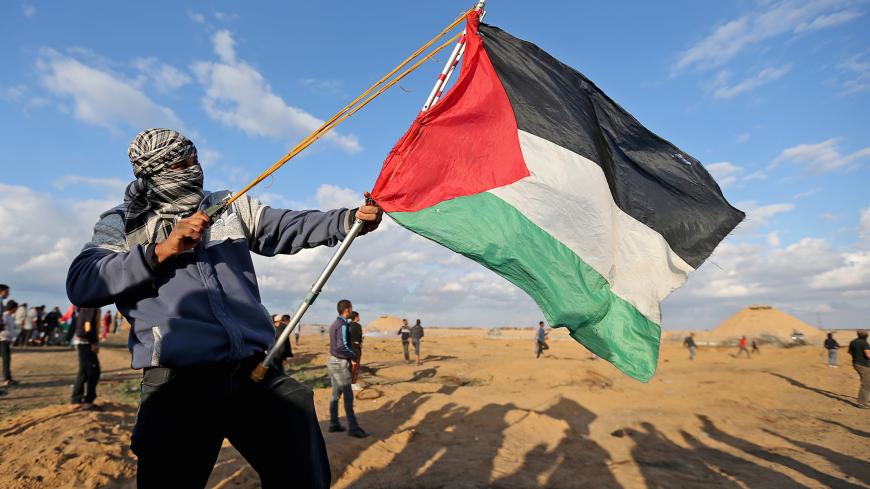 A Palestinian demonstrator uses a sling during an anti-Israel protest at the Israel-Gaza border fence, in the southern Gaza Strip December 6, 2019.  REUTERS/Ibraheem Abu Mustafa - RC2PPD972T6H