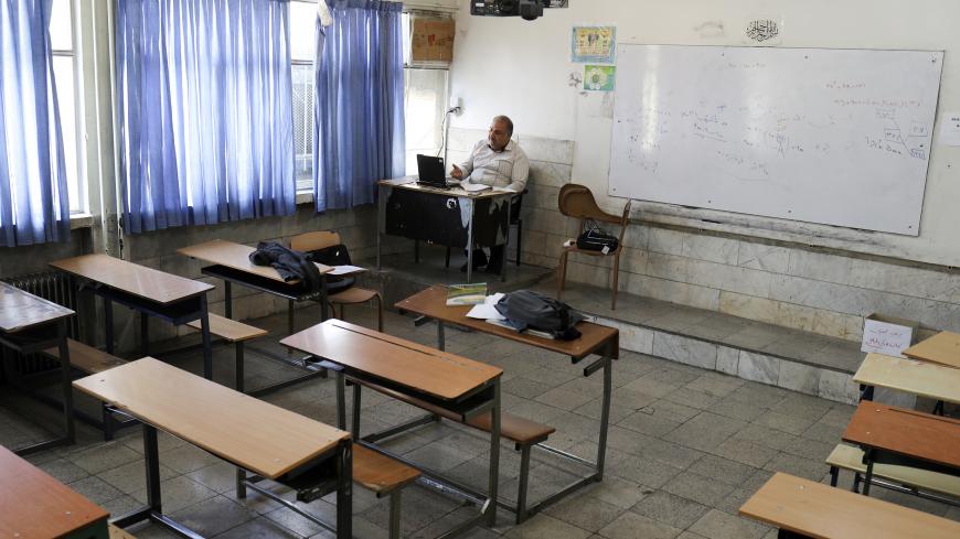 A teacher is seen while teaching online school classes to students at their homes, as schools are still closed, following the outbreak of the coronavirus disease (COVID-19), in Tehran, Iran, April 15, 2020. WANA (West Asia News Agency)/Ali Khara via REUTERS ATTENTION EDITORS - THIS PICTURE WAS PROVIDED BY A THIRD PARTY - RC255G9PZ1I2