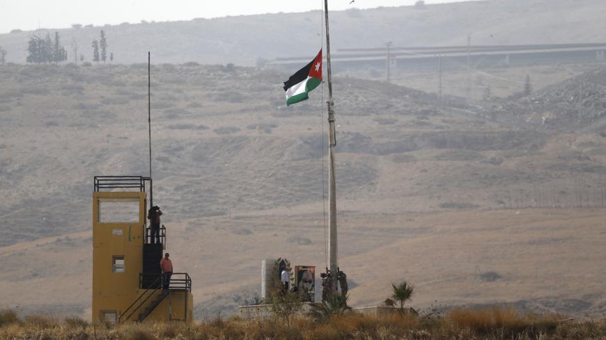 A Picture taken from the Israeli side of the border fence in Naharayim also known as Baqura, shows a Jordanian national flag being raised on a military outpost in the Jordan Valley in Northern Israel, on October 22, 2018. - Jordan's King Abdullah II announced on October 21, 2018 that Jordan has notified Israel it wants to reclaim two small plots of territory leased under their 1994 peace deal, but Israel's Prime Minister Benjamin Netanyahu said he wanted to open negotiations to keep the current arrangement 
