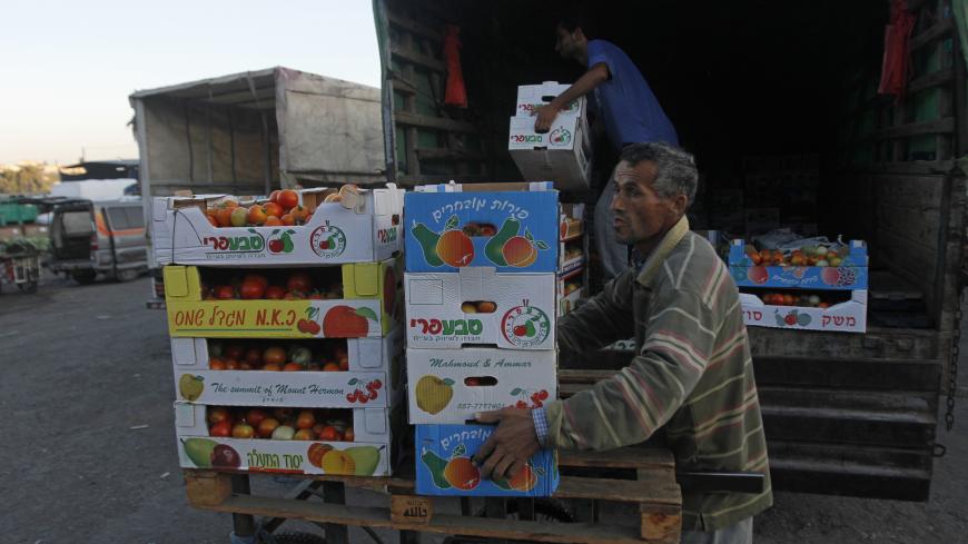 Workers load boxes of tomatoes onto a truck at a wholesale vegetable and fruit market in the West Bank village of Beita, near Nablus September 2, 2012. Once the mainstay of the local economy, Palestinian agriculture in the rocky West Bank is in decline, with farmers struggling to protect both their livelihoods and their lands. Deprived of water and cut off from key markets, farmers across the occupied territory can only look on with a mix of anger and envy as Israeli settlers copiously irrigate their own pl