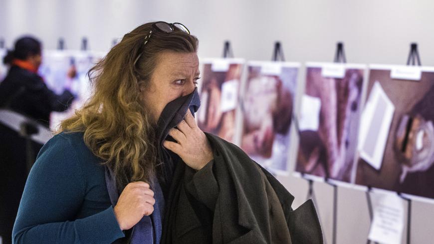 A woman reacts as she looks at a gruesome collection of images of dead bodies taken by a photographer, who has been identified by the code name "Caesar," at the United Nations Headquarters in New York, March 10, 2015. The pictures were smuggled out of Syria between 2011 and mid-2013. The exhibition at the UN consists of two dozen images selected from the roughly 55,000 photographs taken in Syria by a former military police photographer - some showing eye gougings, strangulation and long-term starvation - as