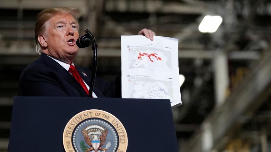 U.S. President Donald Trump shows maps of Syria and Iraq depicting the size of the "ISIS physical caliphate" as he speaks to workers while touring the Lima Army Tank Plant (LATP) Joint Systems Manufacturing Center, the country's only remaining tank manufacturing plant, in Lima, Ohio, U.S., March 20, 2019. REUTERS/Carlos Barria - RC139DF142F0