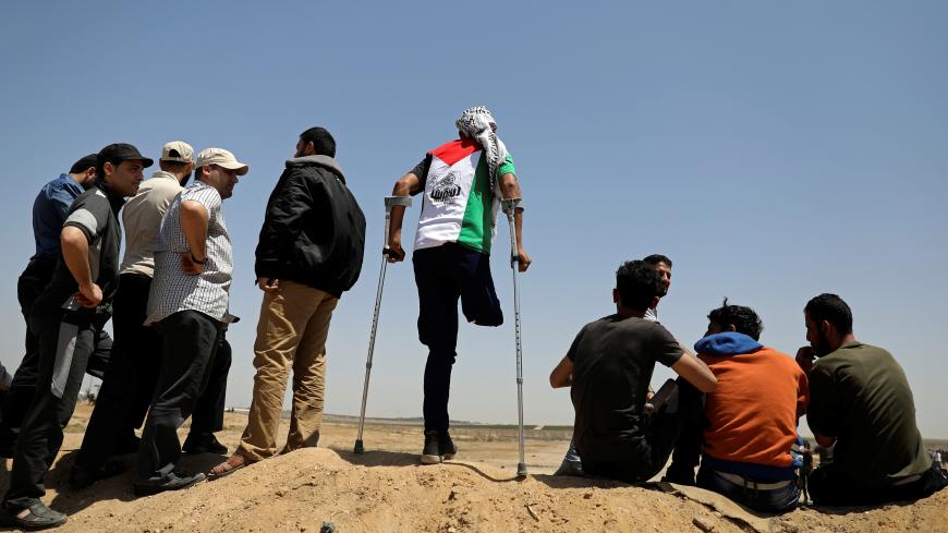 A Palestinian demonstrator with an amputated leg takes part in a protest marking the 71st anniversary of the 'Nakba', or catastrophe, when hundreds of thousands fled or were forced from their homes in the war surrounding Israel's independence in 1948, near the Israel-Gaza border fence, east of Gaza City May 15, 2019. REUTERS/Mohammed Salem - RC1C5CECC660