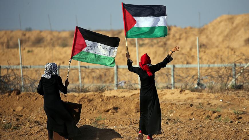 Women wave Palestinian flags during a protest at the Israel-Gaza border fence, in the southern Gaza Strip June 21, 2019. REUTERS/Ibraheem Abu Mustafa - RC18913F8980